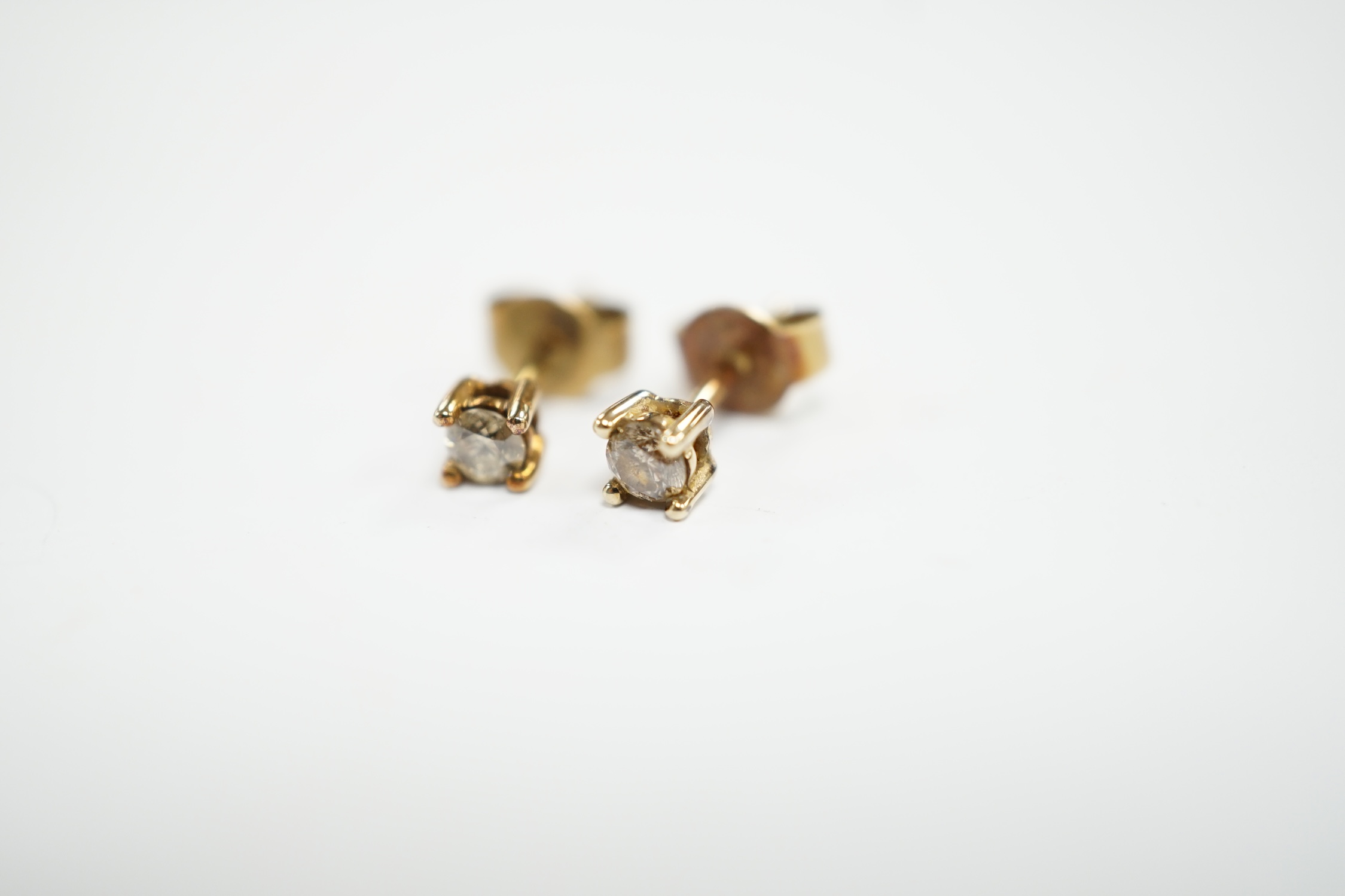 A small pair of 375 and solitaire diamond set ear studs, gross weight 0.8 grams.